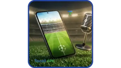 هاتف ذكي حديث يعرض واجهة لعبة كرة قدم خضراء بجوار ميكروفون إذاعي كلاسيكي على أرضية ملعب، يرمز لتجربة تحميل بيس 2017 للأندرويد مع إضافة تعليق فهد العتيبي الصوتي.
